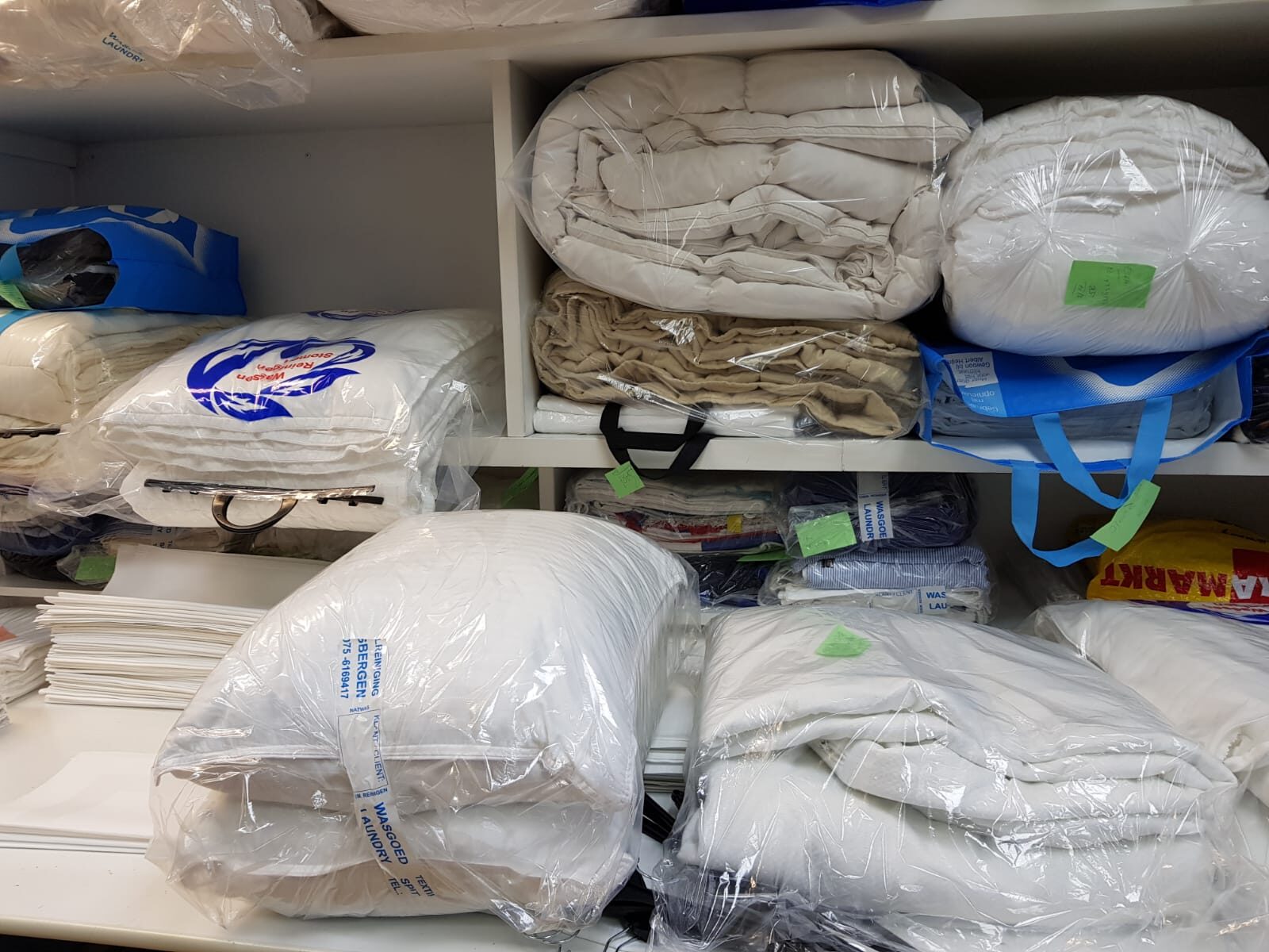 Schone dekbedden en kussens verpakt in de kast